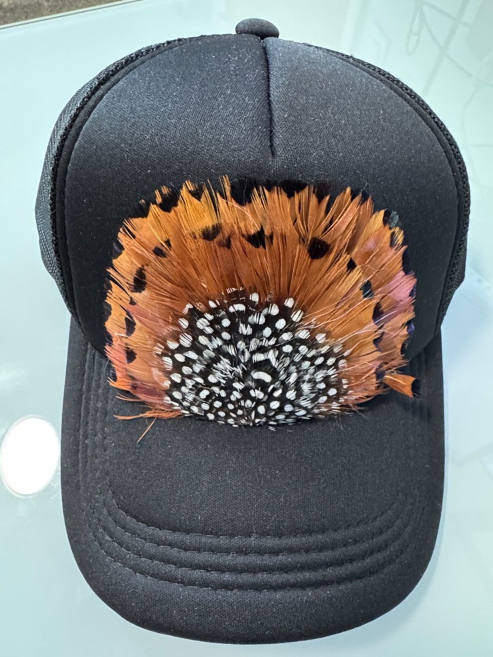 Black Trucker Hat with Decorative Feather design.